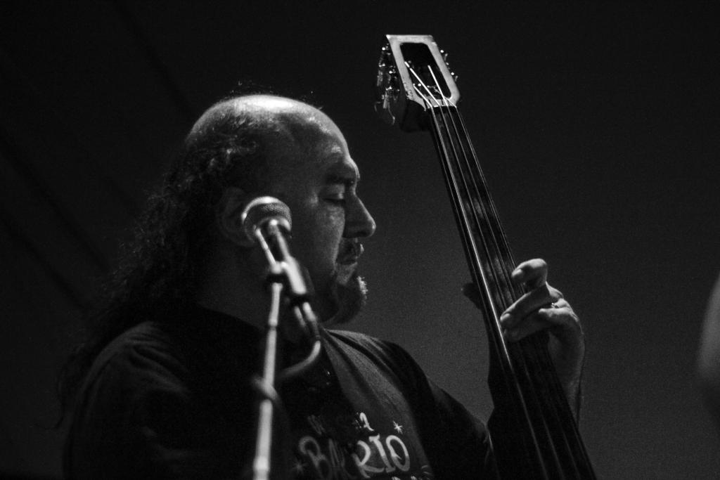 Musician mid-improvisation on stage in blue and violet haze